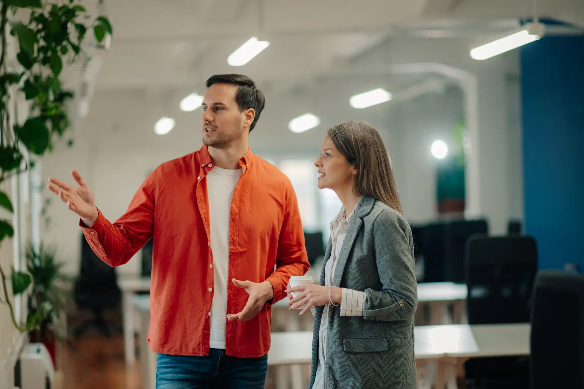Two colleagues discussing strategy in a modern office